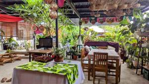 a room with tables and chairs and potted plants at UNK'S HOUSE HOMESTAY in Panglao Island