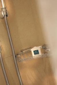 un estante de ducha con una cuchilla de afeitar en AC Hotel by Marriott Ambassadeur Antibes - Juan Les Pins, en Juan-les-Pins