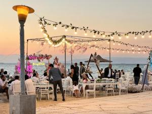 Nozha Beach - Ras Sudr في رأس سدر: مجموعة من الناس يجلسون على الطاولات في حفل زفاف على الشاطئ