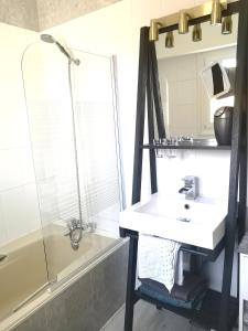 uma casa de banho com um lavatório, um chuveiro e um espelho. em La Demeure des Artistes - Quartier historique em Saintes