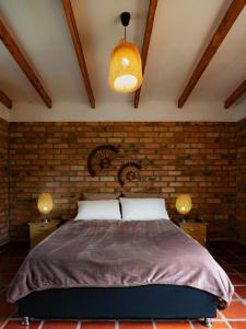 sypialnia z łóżkiem i ceglaną ścianą w obiekcie villa luz de vida w mieście Silvia