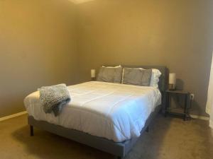 Cozy Condo in Gated Community with Pool by PHX Airport, Tempe, and Old Town في فينكس: غرفة نوم بسرير كبير عليها شراشف ووسائد بيضاء