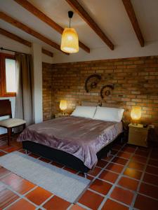 sypialnia z łóżkiem i ceglaną ścianą w obiekcie villa luz de vida w mieście Silvia