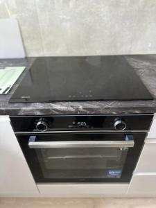 a stove top oven with a black counter top at Manchester City Centre Town House in Manchester