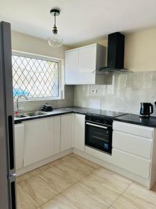 a kitchen with white cabinets and a sink at Manchester City Centre Town House in Manchester