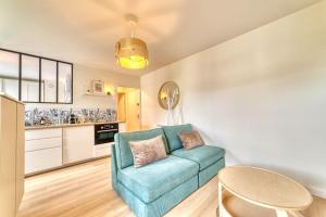 a living room with a blue couch and a table at Le Verde - Ravissant appartement cosy in Saint-Genis-Laval