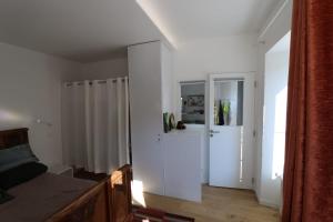 1 dormitorio con paredes blancas, 1 cama y puerta en Les Postillons en Chartreuse en Saint-Pierre-dʼEntremont