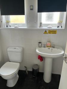 a bathroom with a toilet and a sink at Mells Shells in Hemsby +4 photos