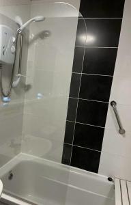 a bathroom with a shower with a glass door at Mells Shells in Hemsby