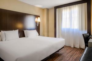 Cette chambre comprend un grand lit blanc et une fenêtre. dans l'établissement AC Hotel Elda by Marriott, à Elda