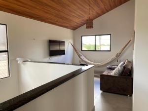 a living room with a couch and a hammock at Casa de Campo em Bananeiras-PB in Bananeiras