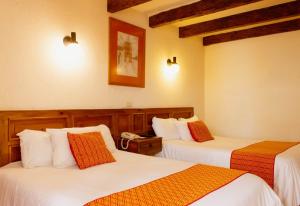 una habitación de hotel con 2 camas en una habitación en Hotel Diego de Mazariegos, en San Cristóbal de Las Casas