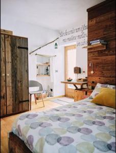 a bedroom with a bed and a desk and a chair at Cozy Chalet next to the Dora Baltea river in Villaret