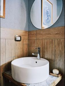 a bathroom with a white sink and two mirrors at Cozy Chalet next to the Dora Baltea river in Villaret