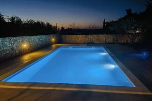 ein Pool in der Nacht mit blauen Lichtern in der Unterkunft Apartments with a swimming pool Stari Grad, Hvar - 4015 in Stari Grad
