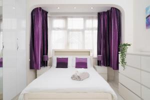 a bedroom with purple curtains and a large bed at Barking Haven Retreat - Airport - Parking - Train Station in Barking