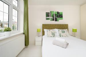 a white bedroom with a white bed and a window at Barking Haven Retreat - Airport - Parking - Train Station in Barking