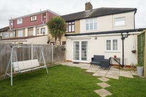 a backyard with a swing and a house at Barking Haven Retreat - Airport - Parking - Train Station in Barking