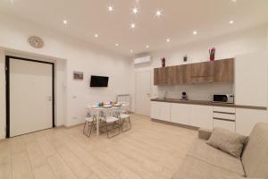 a living room with a table and a kitchen at Stone House Michelle in Torre Annunziata