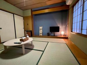 een woonkamer met een tafel en een televisie bij Yuzawa House - Vacation STAY 07044v in Yuzawa