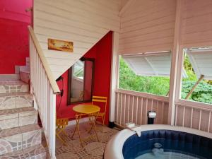 uma casa de banho com uma banheira, uma mesa e janelas em Habitation Bellevue em Le Vauclin