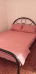 Una cama con sábanas rosas y almohadas. en Orilla Transient 1 en Mabalacat