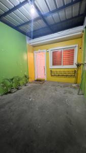 un garaje con puerta rosa y paredes verdes en Orilla Transient 1 en Mabalacat
