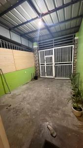 an empty garage with green walls and wooden doors at Orilla Transient 1 in Mabalacat