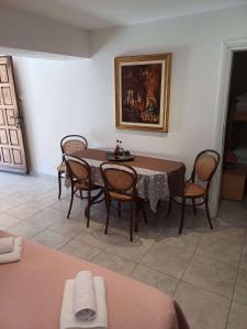 a dining room with a table with chairs and a painting at Apartments with parking spaces Draga Bascanska, Krk - 22861 in Draga Bašćanska