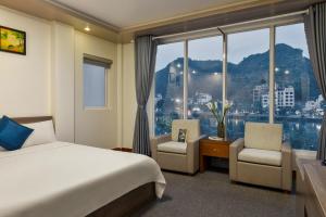 a hotel room with a bed and a large window at Catba Central Hotel 2 in Cat Ba