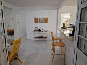 a kitchen with chairs and a counter and a table at Habitation Bellevue in Le Vauclin