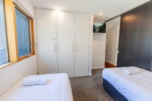 a bedroom with two beds and a closet at Powder 2B in Thredbo