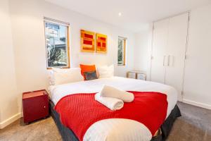a bedroom with a large bed with a red blanket at Powder 2 in Thredbo
