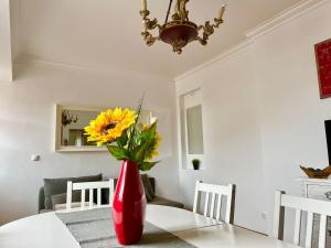 um vaso vermelho com flores amarelas sentado numa mesa em 2 Bedroom, 2 Bathroom With Terrasse - Palma Residence em Lisboa