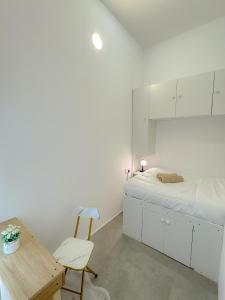 a white bedroom with a bed and a wooden table at Shared Private Room in Downtown Business Bay in Dubai