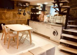 a kitchen with a table and a washing machine at Casa Boutique Marín 1910 in Marín