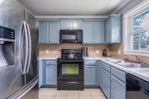 a kitchen with blue cabinets and a stove and a sink at Homely & Alluring 5 bedrooms in Atlanta! in Atlanta