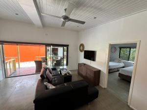 uma sala de estar com um sofá e uma cama em Elluk East Studios em Port Vila