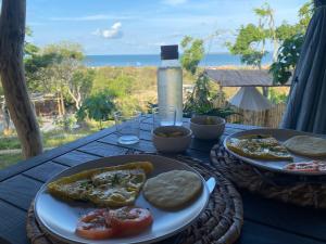 a table with two plates of food on it at Puerta al Mar Ecolodge Glamping in Tubará