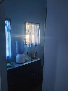 a blue kitchen with a blender and a window at ARSIAM Transient Room in Baguio