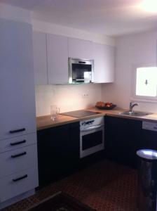 a kitchen with white cabinets and a sink and a stove at Maison de 2 chambres avec jardin clos et wifi a Ploemel in Ploemel