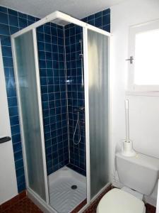 a blue tiled bathroom with a toilet and a shower at Maison de 2 chambres avec jardin clos et wifi a Ploemel in Ploemel