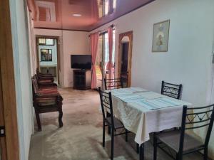 une salle à manger avec une table, des chaises et une télévision dans l'établissement Quinta la Inesperada, à Aguas Claras
