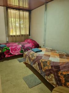 2 Betten in einem Zimmer mit Fenster in der Unterkunft Quinta la Inesperada in Aguas Claras
