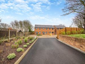 a brick house with a fence and a driveway at Curlew Retreat - Uk46780 in Ellington