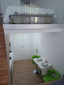 Habitación pequeña con mesa y 2 sillas verdes en ZIL - Studio Apartment City Center, en Zagreb