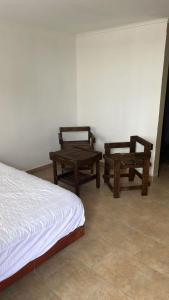 - une chambre avec deux tables, un lit et un banc dans l'établissement Hangar 15, à Playa Dorada