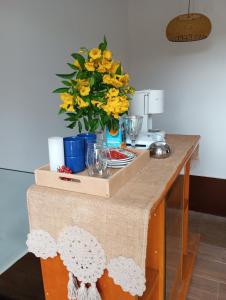 uma mesa com um vaso de flores amarelas em Habitaciones con amplia terraza em Encarnación