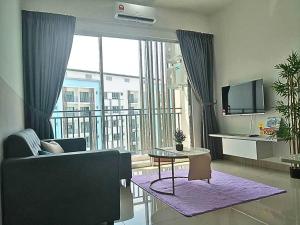 a living room with a couch and a large window at Bayu Temiang Seremban- Your Urban Retreat in Seremban