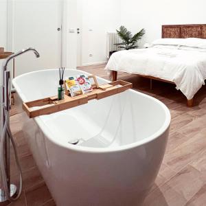 bañera blanca en una habitación con cama en Maison Frida • Tivoli, en Tívoli